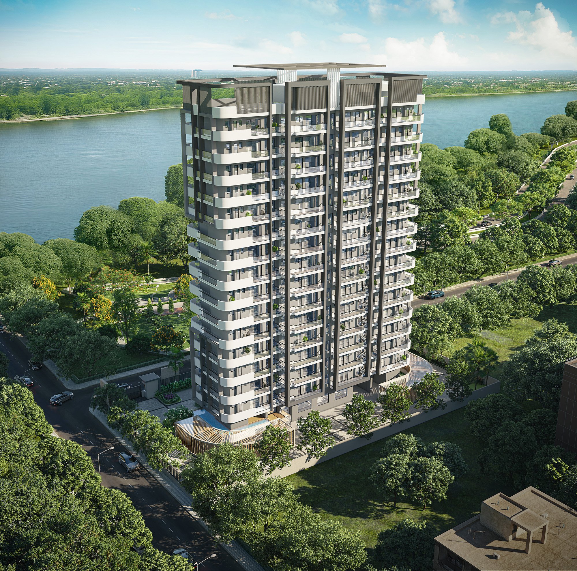 A modern high-rise residential building with balconies, situated in a green area near a river, under a partly cloudy sky.