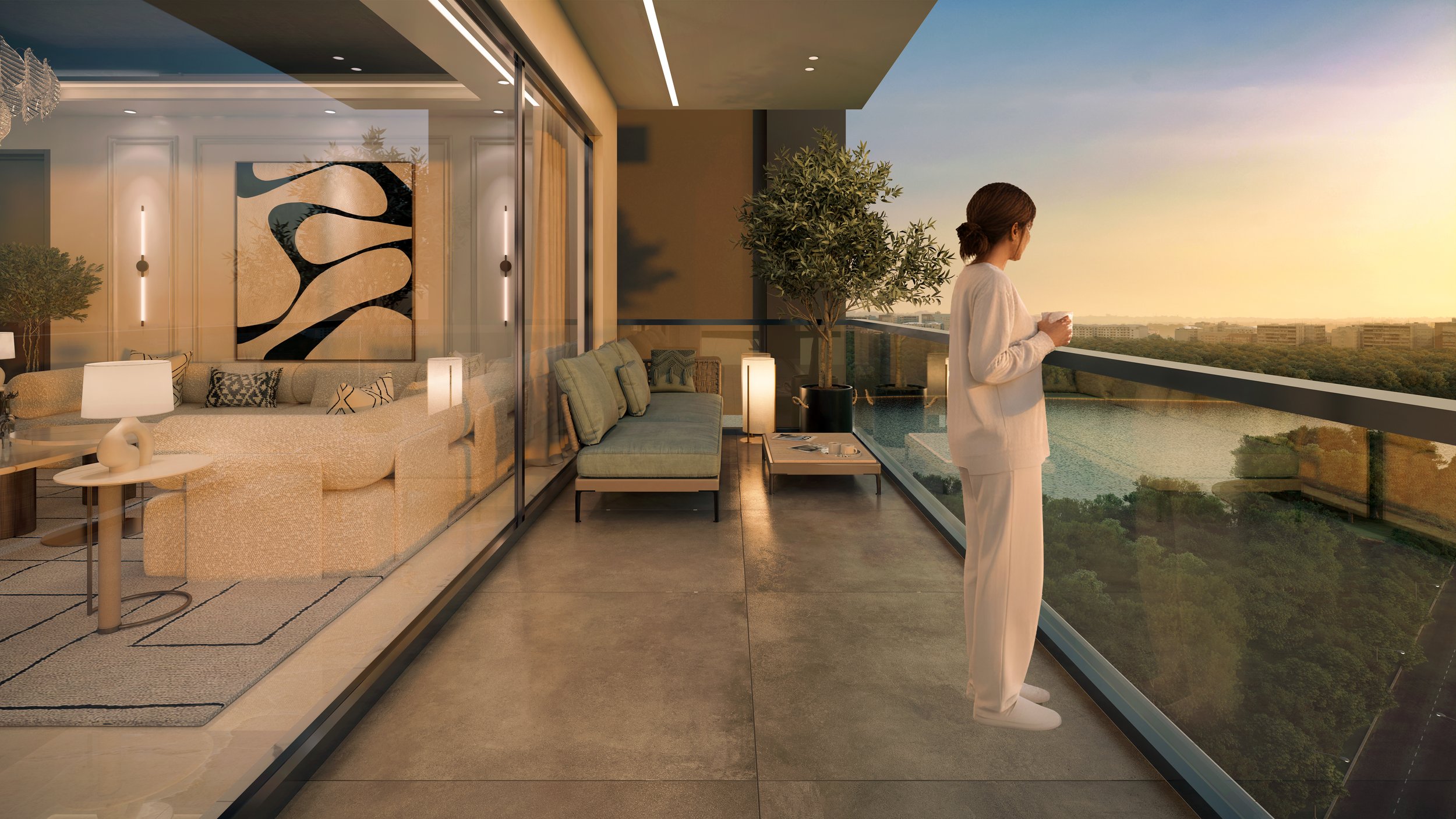 A woman in white pajamas stands on a balcony, holding a cup and looking at the sunset over trees and buildings. The background shows a clear sky with a sunset. Inside, through glass doors, a living room with beige sofa, lamps, art piece, and decorative pillows is visible.
